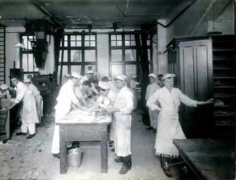 Bakery School students working in white aprons, around 1910